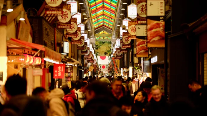 Crowds exploring Nishiki Market in Kyoto, a bustling food and souvenir street easily accessible from a Kyoto hotel near the city centre.