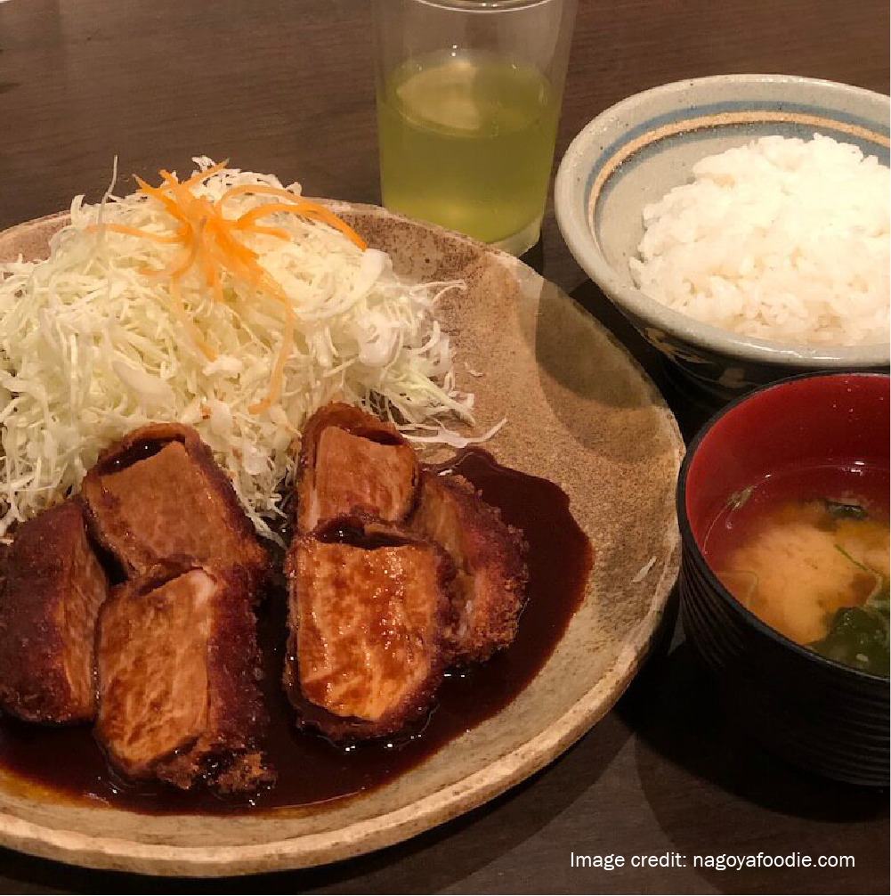 Traditional miso katsu meal in Nagoya featuring pork cutlet with rich red miso sauce, shredded cabbage, rice, and miso soup near Nagoya hotels.