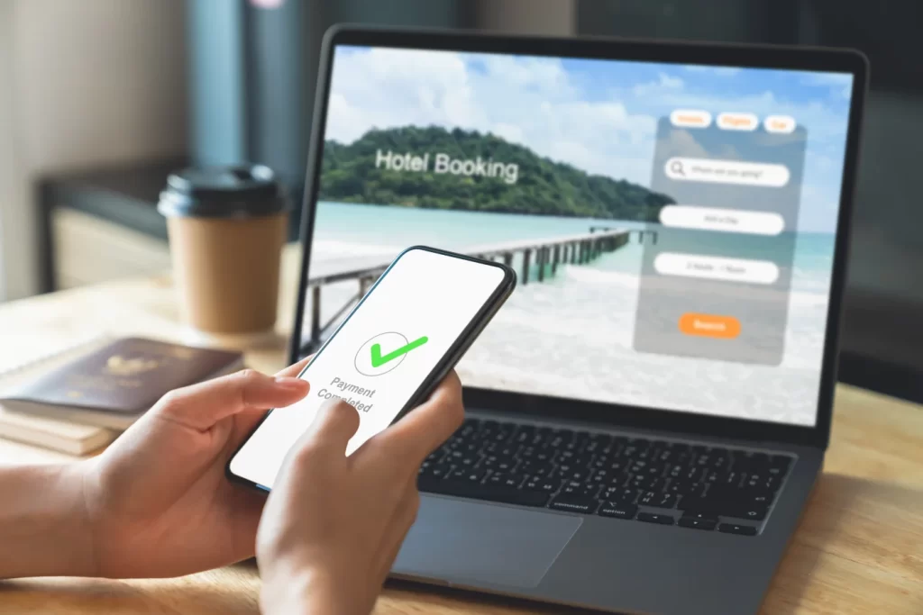 a phone and a laptop being used for booking a malaysia hotel